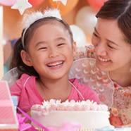 Birthday girl smiles in front of cake