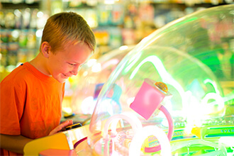 Young boy plays game in arcade